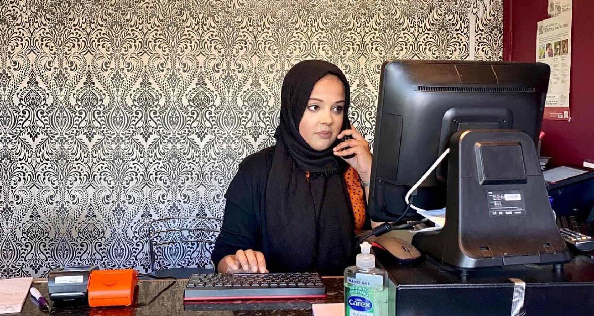 Lady taking an order for an indian takeaway.